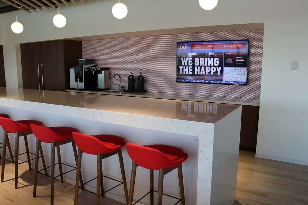 Dairy Queen digital signage screen from Reach Media Network featured in employee break room, displaying local map, social posts, and corporate messaging.