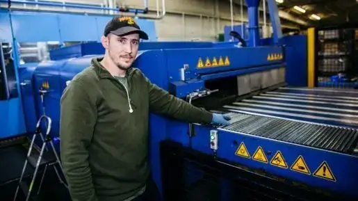 factory worker standing in front of machinery, Reach Media Network digital signage